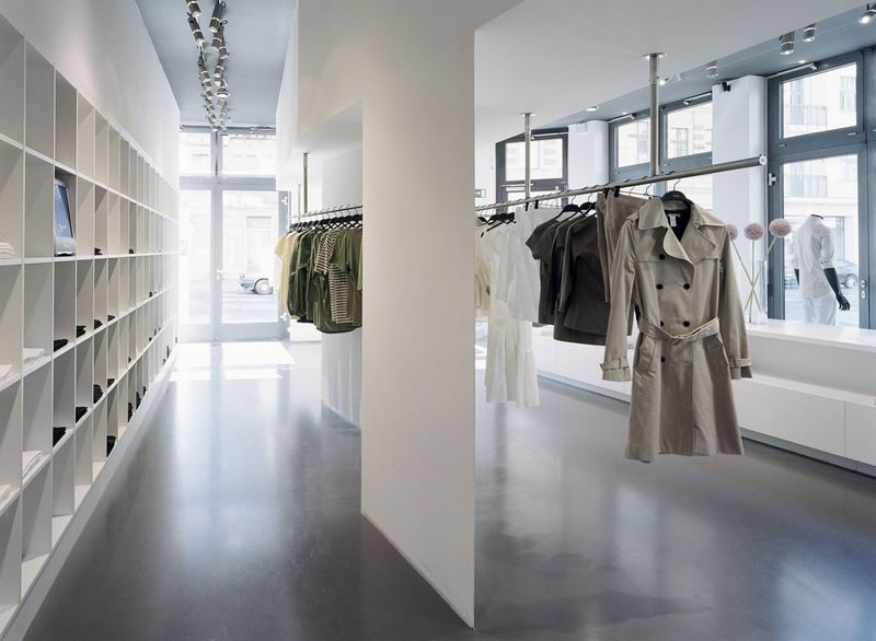 Erdgeschoss der Modeboutique Filippa K mit Wandregalen und Kleiderstangen